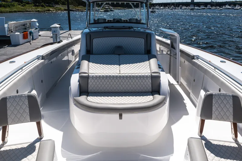 Slide: The Image of 2025 Valhalla Boatworks V-46 luxury yacht interior with quilted seating, docked by the water. - 24
