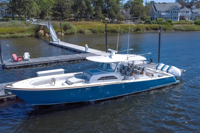 Slide: The Image of 2025 Valhalla Boatworks V-46 docked on a serene waterfront with lush greenery. - 36