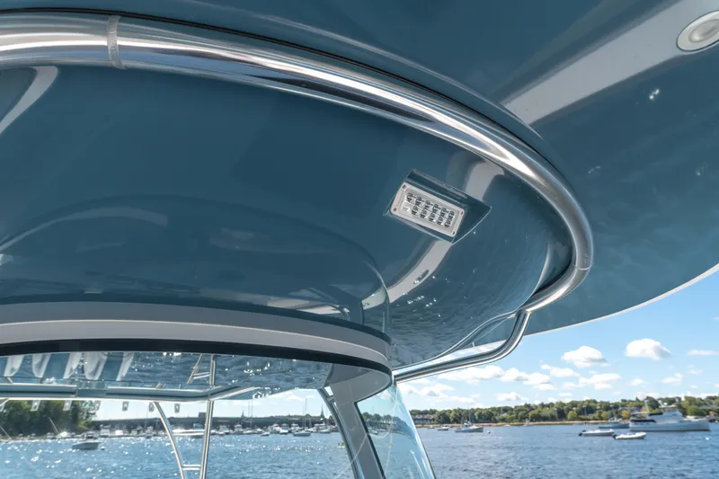 Slide: The Image of 2025 Valhalla Boatworks V-46, blue canopy detail, overlooking scenic waterfront. - 8