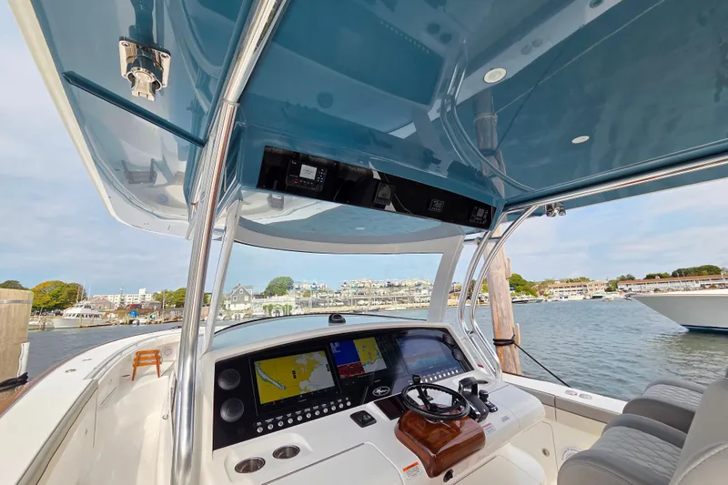 Slide: The Image of 2025 Valhalla Boatworks V-46 helm with advanced navigation system, docked in a scenic marina. - 9