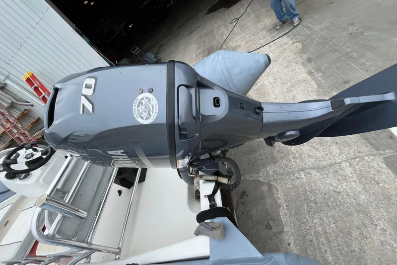 Slide: The Image of 2019 Zodiac Open 4.8 boat with Yamaha 70 outboard motor, docked on concrete. - 2