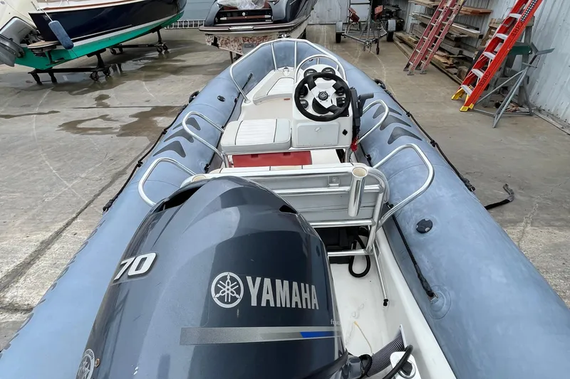 Slide: The Image of 2019 Zodiac Open 4.8 boat with Yamaha 70 engine in a storage area. - 9