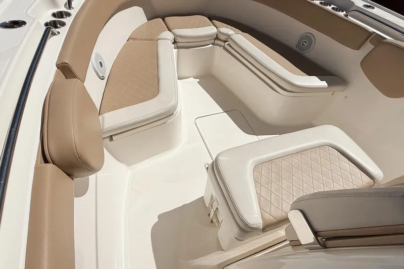 Slide: The Image of 2019 Pioneer 266 Pelagic boat interior with beige cushioned seating and storage compartments. - 15