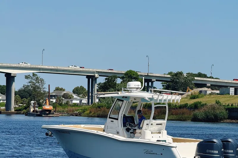 Slide: The Image of 2019 Pioneer 266 Pelagic boat on calm water near a bridge and shoreline. - 2