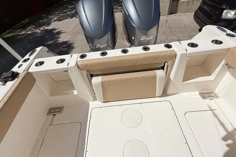 Slide: The Image of 2019 Pioneer 266 Pelagic boat interior with Yamaha 250 engines, featuring beige seating and cup holders. - 24