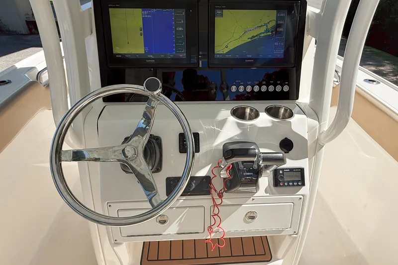 Slide: The Image of Control panel of a 2019 Pioneer 266 Pelagic boat with navigation screens and steering wheel. - 32