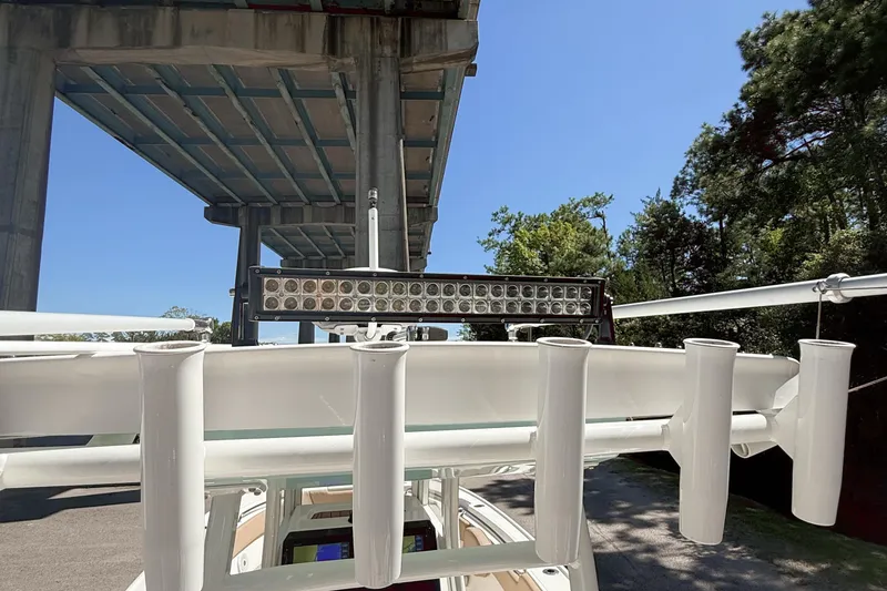 Slide: The Image of 2019 Pioneer 266 Pelagic boat under bridge, featuring rod holders and LED light bar. - 37