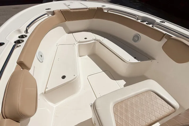 Slide: The Image of 2019 Pioneer 266 Pelagic boat interior with tan cushioned seating and storage compartments. - 39