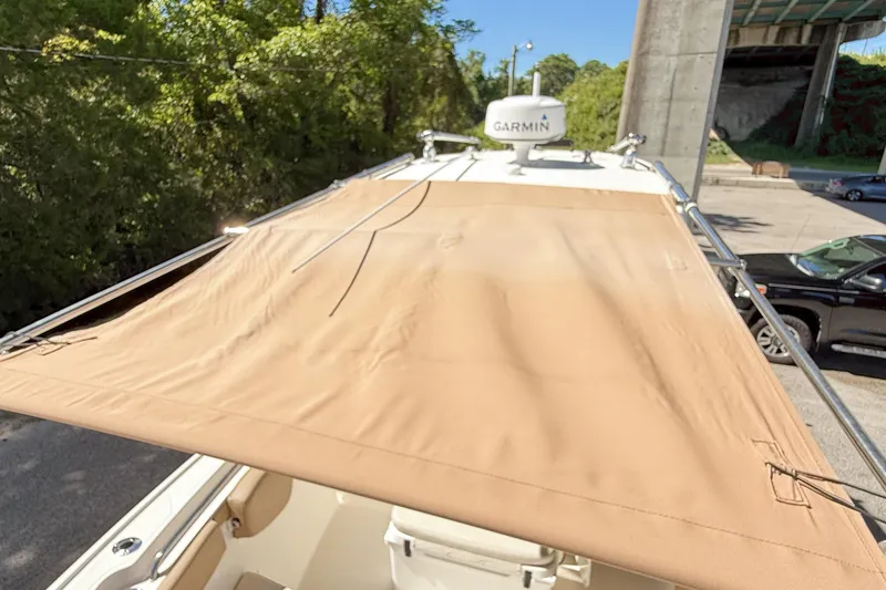 Slide: The Image of 2019 Pioneer 266 Pelagic boat with tan canopy and Garmin radar, parked under a bridge. - 41