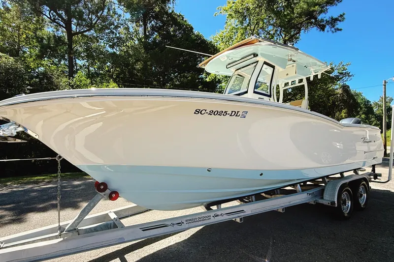 Slide: The Image of 2019 Pioneer 266 Pelagic boat on trailer, surrounded by trees, under clear blue sky. - 5