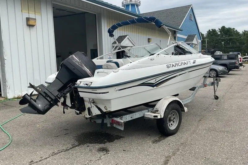 Slide: The Image of 1999 Starcraft 1809 Fish & Ski boat on trailer, parked outside a building. - 11
