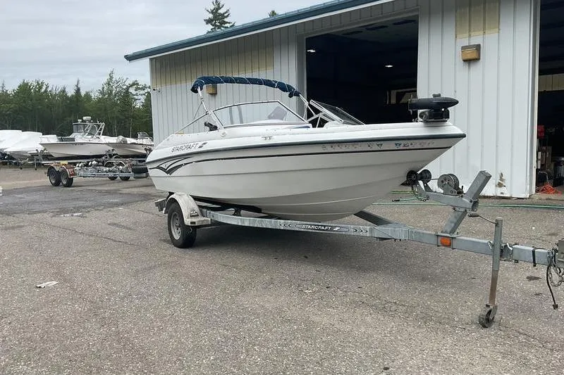 The Image of 1999 Starcraft 1809 Fish & Ski boat on trailer outside a storage facility. - 2