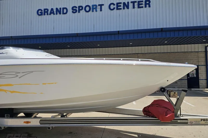 Slide: The Image of 2002 Baja 25 Outlaw boat on trailer at Grand Sport Center. - 13