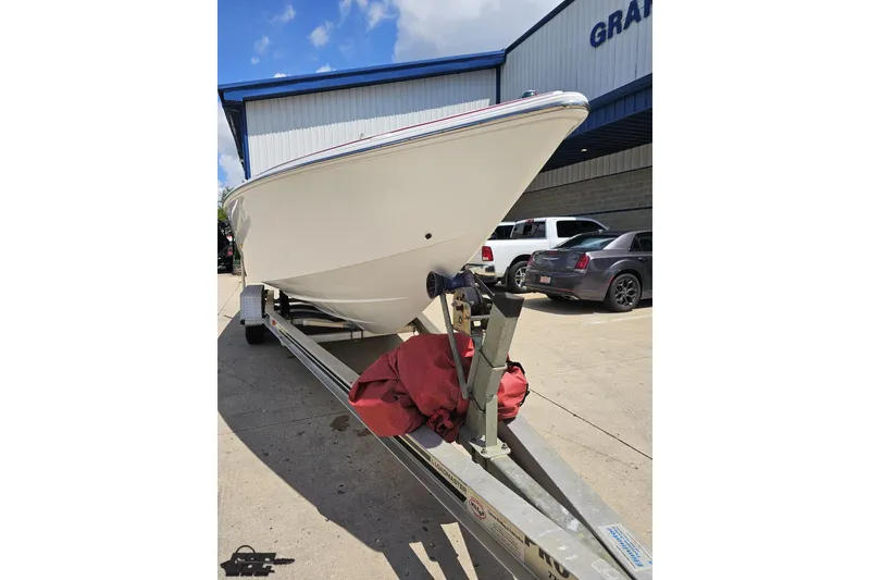 Slide: The Image of 2002 Baja 25 Outlaw boat on trailer, parked outside a building. - 15