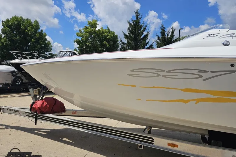Slide: The Image of 2002 Baja 25 Outlaw boat on trailer under blue sky. - 22