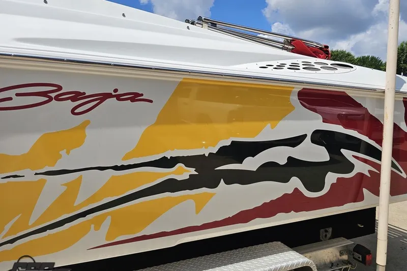 Slide: The Image of 2002 Baja 25 Outlaw boat with vibrant yellow, black, and red graphics. - 24