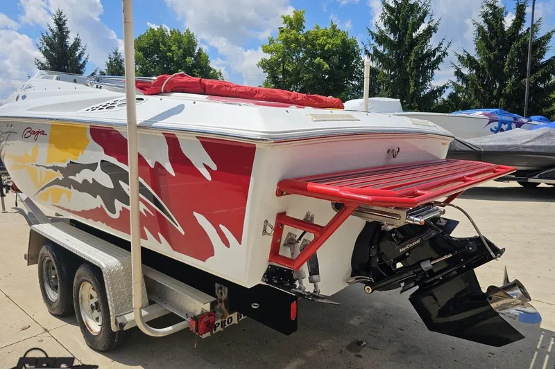 Slide: The Image of 2002 Baja 25 Outlaw boat with vibrant graphics on a trailer, featuring a MerCruiser engine. - 28