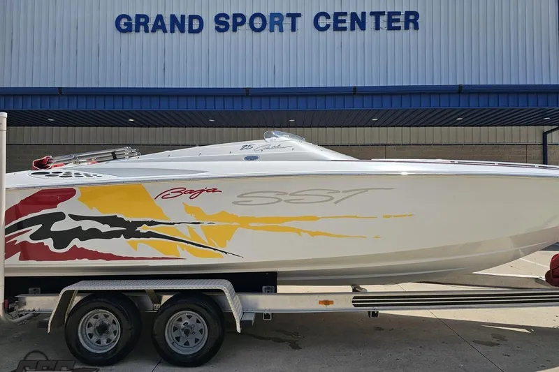 Slide: The Image of 2002 Baja 25 Outlaw boat with colorful graphics at Grand Sport Center. - 3