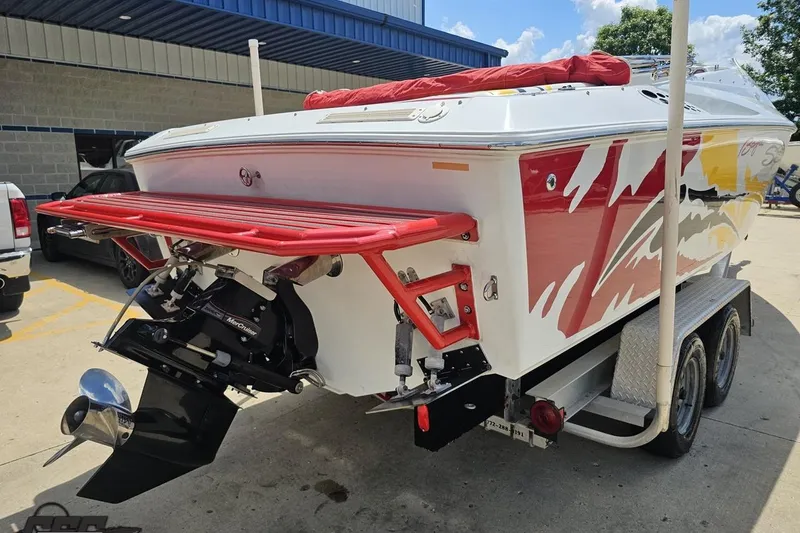 Slide: The Image of 2002 Baja 25 Outlaw boat with vibrant graphics on a trailer. - 34