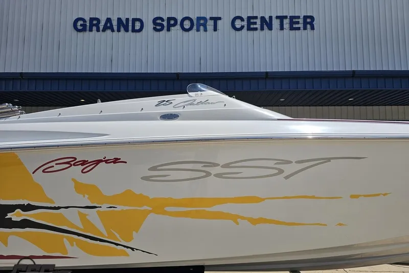 Slide: The Image of 2002 Baja 25 Outlaw boat at Grand Sport Center, featuring vibrant graphics. - 4
