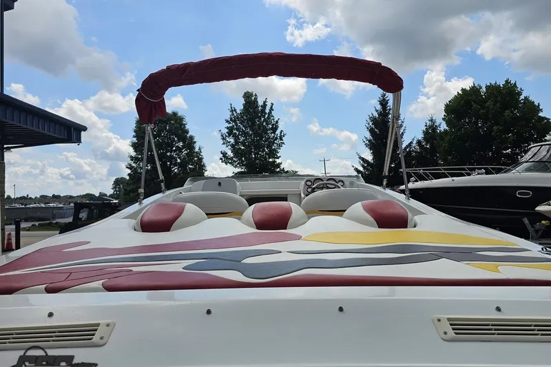 Slide: The Image of 2002 Baja 25 Outlaw speedboat with colorful seating and canopy, parked outdoors. - 42