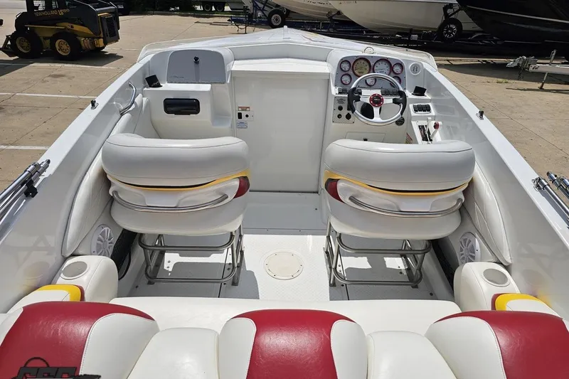 Slide: The Image of 2002 Baja 25 Outlaw boat interior with white and red seating, steering wheel, and dashboard. - 44