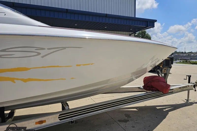 Slide: The Image of 2002 Baja 25 Outlaw boat on trailer, parked outdoors under blue sky. - 5
