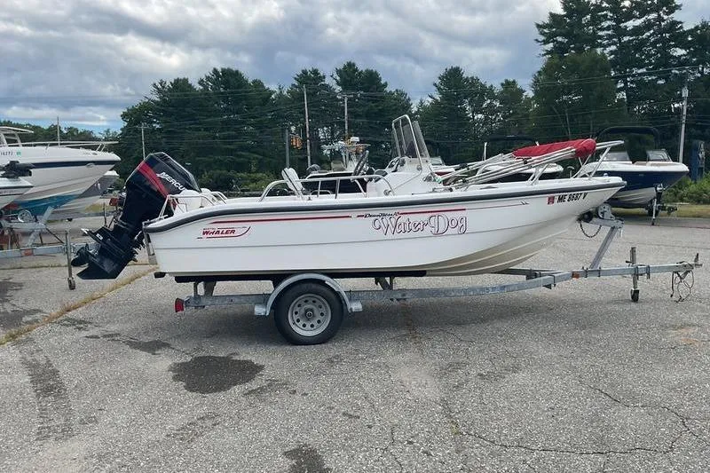 Slide: The Image of 2000 Boston Whaler 160 Dauntless boat on trailer, parked outdoors. - 2