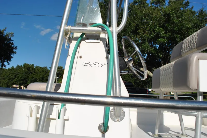 Slide: The Image of 2005 Cape Horn 22 Bay boat interior with steering wheel and seating, under clear blue sky. - 22