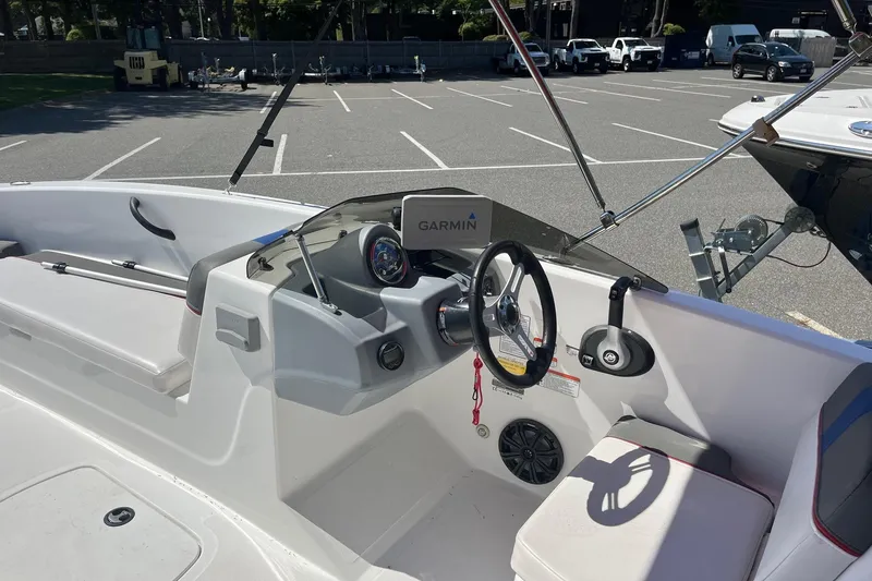 Slide: The Image of 2022 Tahoe T18 boat interior with Garmin navigation, steering wheel, and seating in a parking lot. - 5