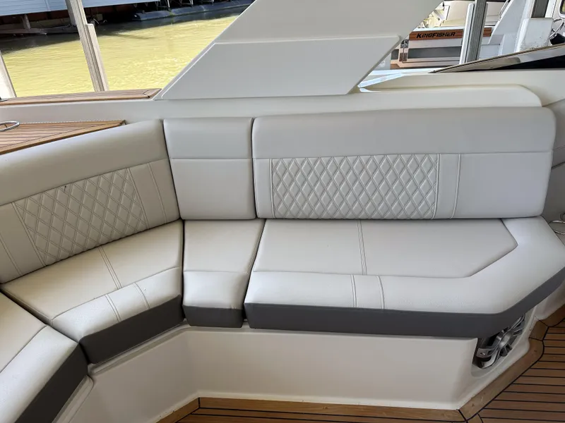 Slide: The Image of 2023 Sea Ray SLX 310 OB boat interior with white cushioned seating. - 4