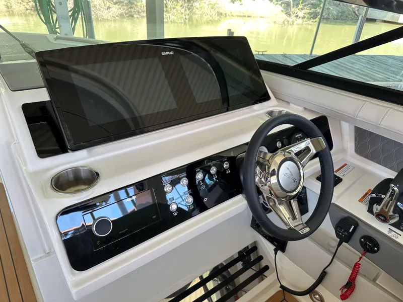 Slide: The Image of 2023 Sea Ray SLX 310 OB helm with modern controls and touchscreen display. - 7
