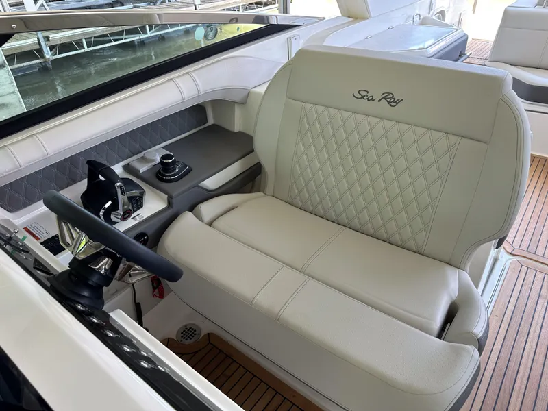 Slide: The Image of 2023 Sea Ray SLX 310 OB helm seat with beige upholstery and diamond stitching. - 9