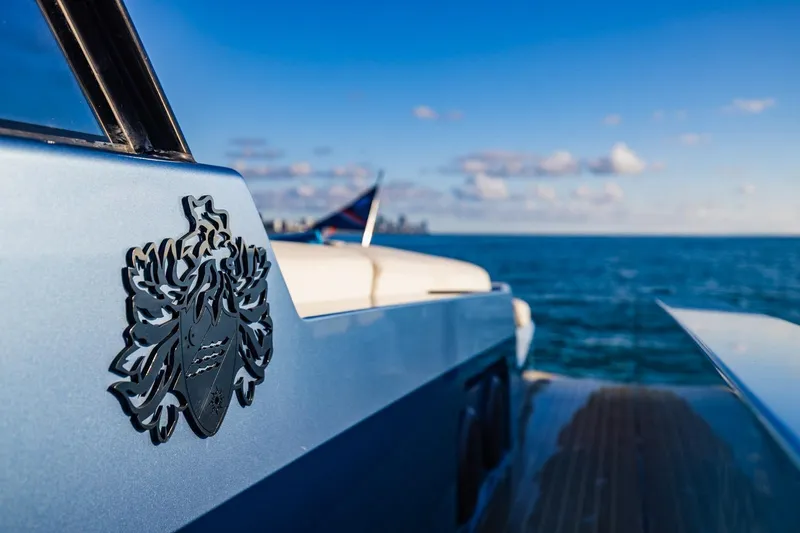 Slide: The Image of 2019 Vanquish Yachts VQ58 on open sea, showcasing sleek design and emblem. - 13