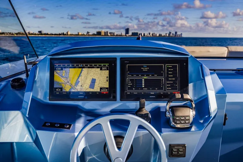 Slide: The Image of 2019 Vanquish Yachts VQ58 helm with navigation screens, steering wheel, and ocean view. - 24