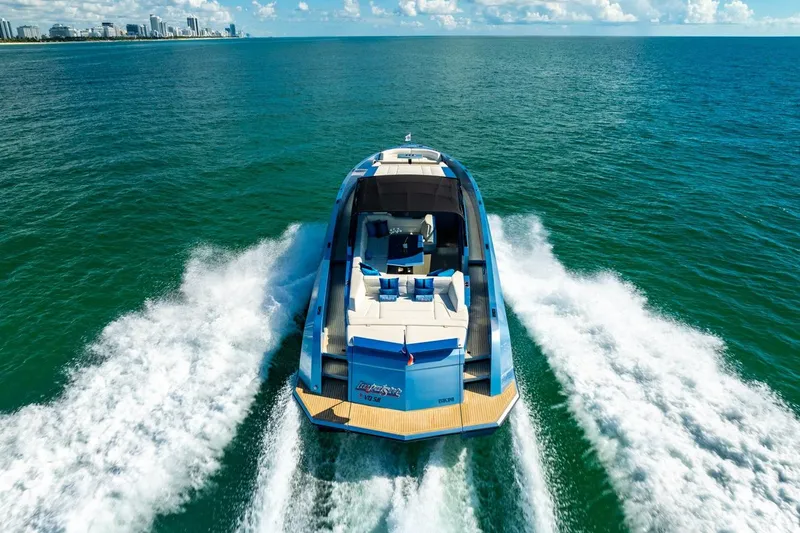 Slide: The Image of 2019 Vanquish Yachts VQ58 cruising on open water, city skyline in background. - 3