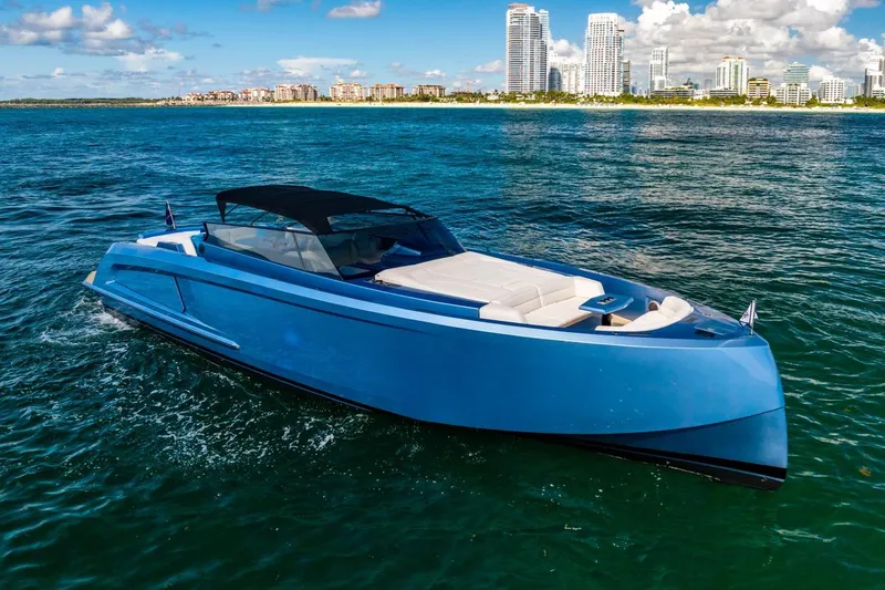 Slide: The Image of 2019 Vanquish Yachts VQ58 cruising on ocean with city skyline backdrop. - 4