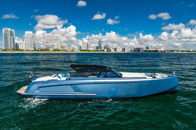 Slide: The Image of 2019 Vanquish Yachts VQ58 cruising near a city skyline under a blue sky. - 8