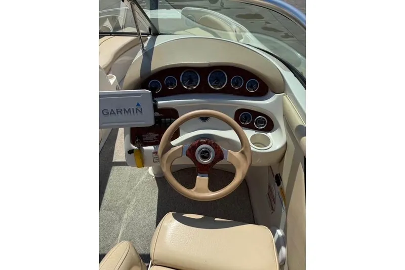 Slide: The Image of 2002 Sea Ray 210 Sundeck dashboard with Garmin GPS and beige interior. - 2