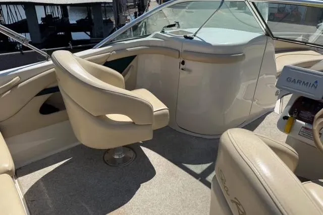 Slide: The Image of Interior of 2002 Sea Ray 210 Sundeck boat with beige seating and Garmin equipment. - 4