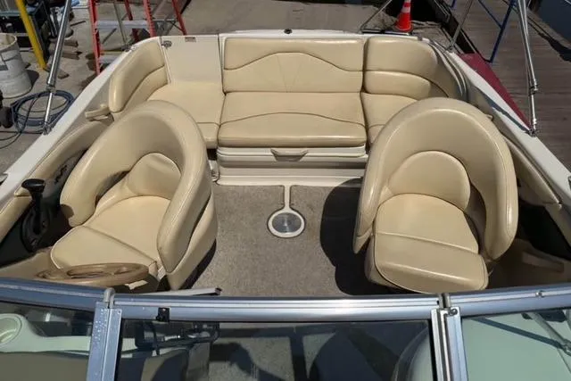 Slide: The Image of 2002 Sea Ray 210 Sundeck interior with beige seating and steering wheel. - 5