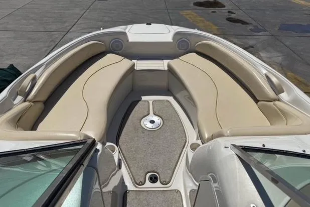 Slide: The Image of 2002 Sea Ray 210 Sundeck boat interior with beige seating and carpeted floor. - 6