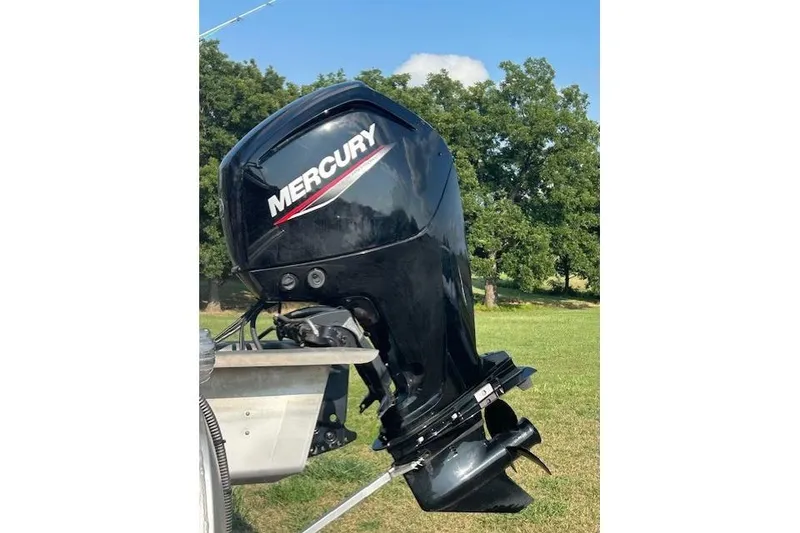 Slide: The Image of 2023 Sun Tracker Bass Buggy 18 DLX with Mercury outboard motor in grassy area. - 3