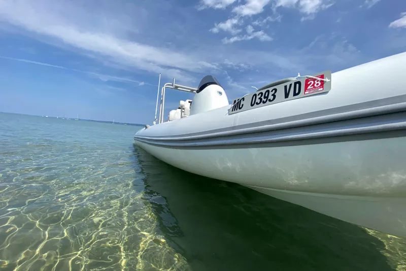 Slide: The Image of 2013 Mercury Inflatables M570 boat on clear water under blue sky. - 10