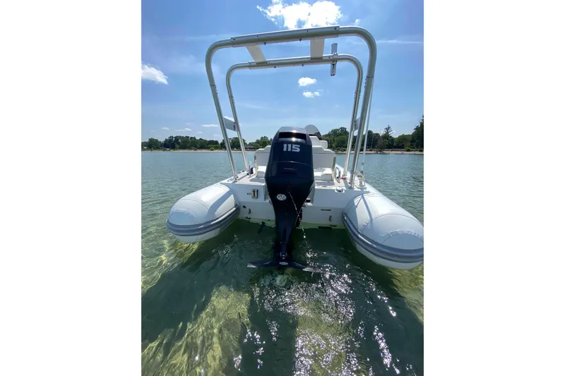 Slide: The Image of 2013 Mercury Inflatables M570 boat on clear water, rear view with motor. - 5