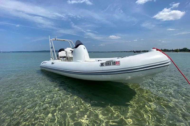Slide: The Image of 2013 Mercury Inflatables M570 boat on clear water under blue sky. - 8