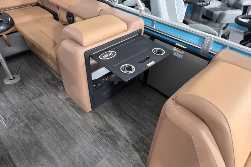 Slide: The Image of 2026 Godfrey SWEETWATER 2486 SFL interior with fold-out table and cup holders. - 2