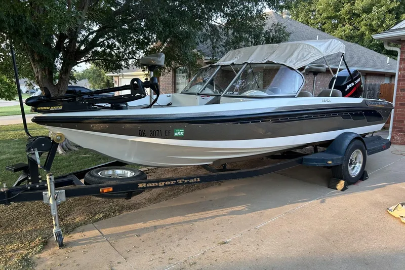 Slide: The Image of 2004 Ranger 190 VS boat on trailer, parked in driveway, with canopy and motor. - 1