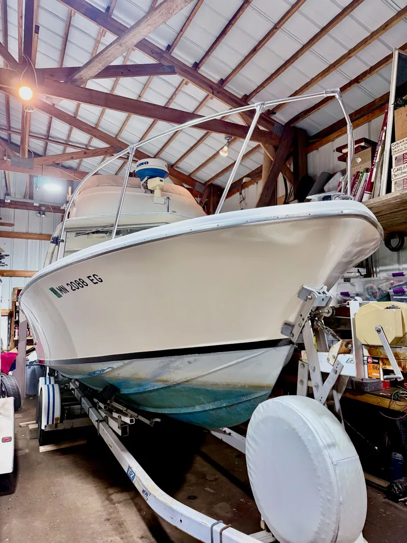 The Image of 1973 Bertram Sport Fisherman boat on trailer in a wooden garage. - 0