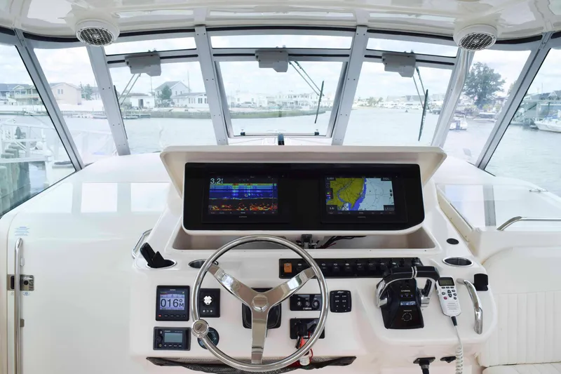 Slide: The Image of 2012 Grady-White Express 360 helm with navigation screens and steering wheel, dockside view. - 10